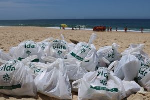 Alunos do projeto Onda Certa recolhem lixo na praia da Barra