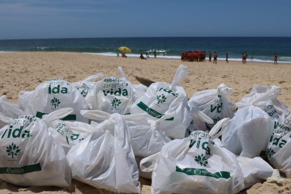 Alunos do projeto Onda Certa recolhem lixo na praia da Barra